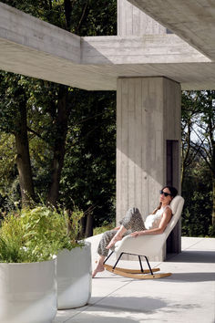 a woman sitting in a rocking chair outside