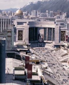 an aerial view of a city with buildings and mountains in the backgroung