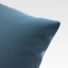 a blue pillow is sitting on a white surface