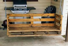 a porch swing made out of wooden pallets with a grill in the back ground