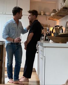 two men standing in a kitchen talking to each other