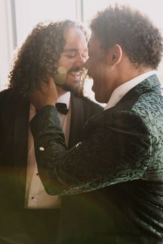 two men in tuxedos are smiling and touching each other's foreheads