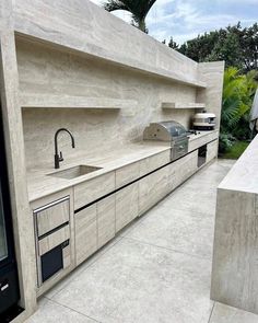 an outdoor kitchen with concrete counter tops and cabinets