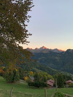 the mountains are in the distance with houses on each side and a fence around them