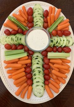 carrots, cucumbers, celery and tomatoes arranged on a platter