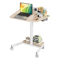 a laptop computer sitting on top of a wooden table next to a small white cart