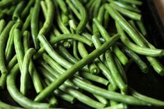 green beans are sitting in a black tray