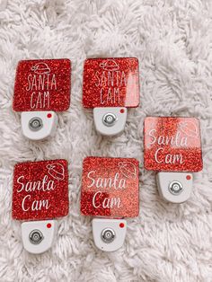 four red santa cam night light holders on a white carpet with the words santa cam printed on them