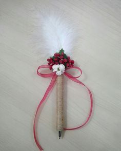 a pen with flowers and feathers attached to it