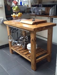 a kitchen island with pots and pans on it in the middle of a tile floor