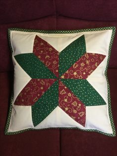 a red and green pillow sitting on top of a couch