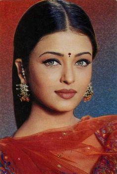 an old photo of a woman with big earrings on her head and wearing a sari