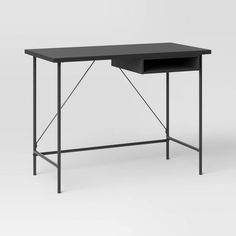 the desk is black and has a metal frame around it's top, with an open drawer at the bottom