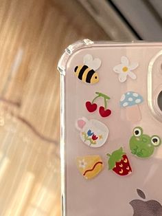 an apple phone case with stickers on the front and back sides, sitting on a table