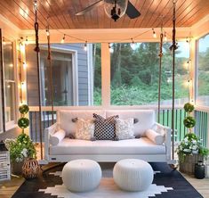 a porch with white furniture and lights on the ceiling is decorated in black and white