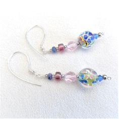 These beautiful Boho 'Flower Earrings', are constructed using non tarnish silver wire, and the ear wires are hammered, for a luxurious effect. Included are stunning Millefiori glass beads, showing fascinating floral inclusions, in blue, pink, yellow, green, and, light brown. Dark pink Czech glass drum beads, large round, pink, Czech glass facetted beads, and small blue fire polished Czech glass Rondelle beads also star in these fabulous earrings. Nickel Free Multicolor Beaded Sterling Silver Earrings, Silver Beaded Earrings With Round Glass Beads, Adjustable Czech Glass Earrings With Faceted Beads, Nickel Free Glass Round Bead Earrings, Glass Earrings With Faceted Beads As A Gift, Wire Wrapped Glass Bead Earrings, Glass Dangle Jewelry With Faceted Beads, Glass Earrings With Faceted Beads For Gift, Gift Beaded Flower Earrings With Czech Glass