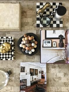 a table topped with pictures and other items on top of a tile floor covered in black and white checkered tiles