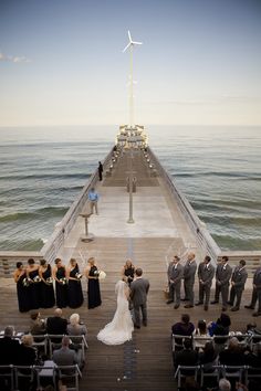 a couple getting married at the end of a pier