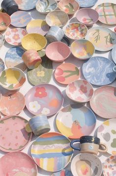 a pile of colorful plates sitting on top of a white table next to each other