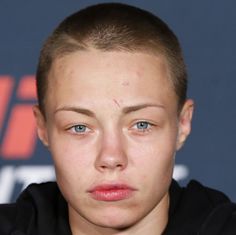 a close up of a person wearing a black hoodie and looking at the camera