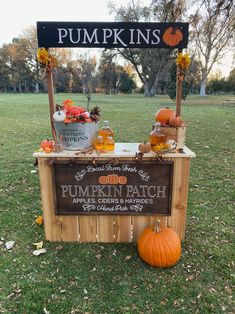 an outdoor pumpkin patch is set up in the grass with a sign and potted plants