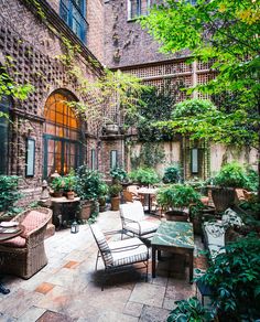 an outdoor patio with chairs, tables and potted plants