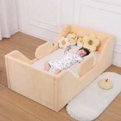 a baby is laying in a bed with stuffed animals on the floor next to it