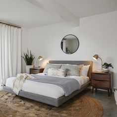 a bedroom with a large bed and white walls