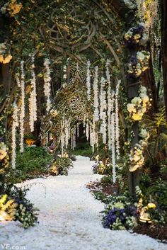 an image of a garden with flowers on the ground and trees in the background that have been decorated