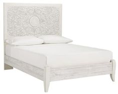 a white bed with an intricate headboard and foot board on the bottom half of it