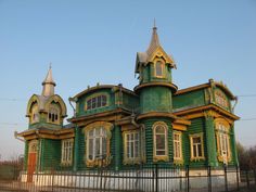 a large green and yellow house with two towers