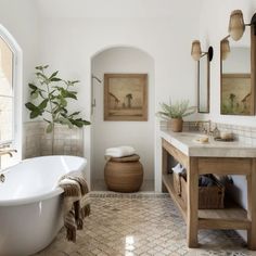 a bath room with a tub a sink and mirrors