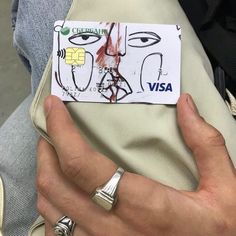 a person holding a visa card in their left hand and wearing a ring on the other