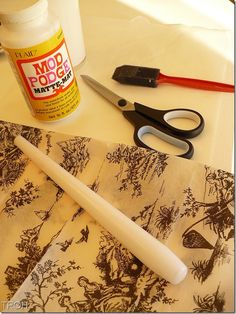 scissors, glue, and other crafting supplies are on a table with paper towels