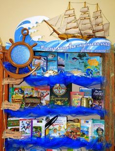 there is a book shelf with books on it and a pirate ship in the background