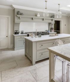 a large kitchen with an island in the middle and marble counter tops on both sides