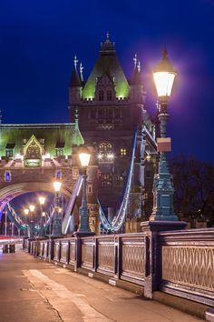 the tower bridge is lit up at night