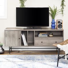 a flat screen tv sitting on top of a wooden entertainment center