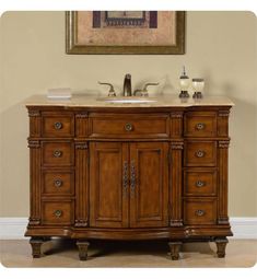 a bathroom vanity with two sinks and a painting on the wall