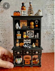 a miniature halloween shelf with pumpkins and other decorations