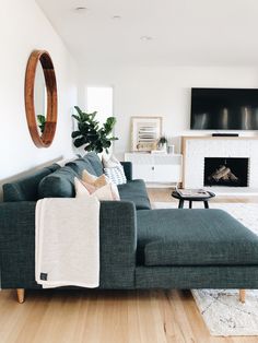 a living room filled with furniture and a flat screen tv mounted on a wall above a fire place