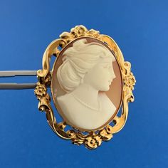 * Estate 14K Yellow Gold Carved Cameo Floral Scroll Bezel Pin Brooch Pendant * Length: 1-3/4" including the bale * Width: 1-3/8" * Oval Carved Cameo measures: approximately 1-1/4" x 7/8" * Pendant/Brooch weight: 8.2 tgw * Marked: MAKERS MARK * 14K * Chain is not included, but can be purchased for an additional price. * Condition: As pictured. * G2843 5% Restocking Fee    Exported By ExportYourStore :) Luxury Yellow Gold Cabochon Brooches, Luxury Cabochon Brooches For Anniversary, Luxury Anniversary Brooches With Cabochon, Luxury Gold Brooches With Cabochon, Luxury Round Brooches For Collectors, Luxury Round Collectible Brooches, Classic Cameo Brooches For Wedding, Classic Gold Intaglio Brooch, Classic Gold Brooch With Intaglio Detail