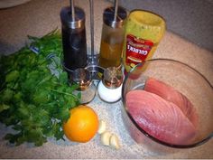 an assortment of ingredients on a counter including meat, oranges and other foodstuffs