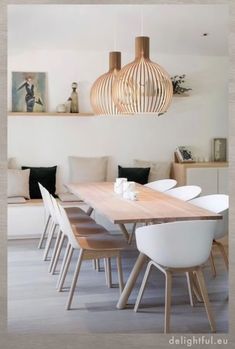 a dining room table with white chairs around it