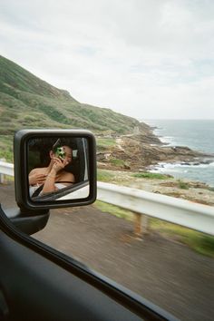 a man is seen in the rear view mirror of a car