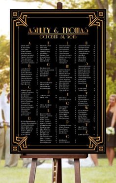 a black and gold wedding seating chart on an easel in front of some people