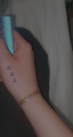 a person with a small tattoo on their arm holding a blue object in her hand