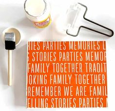 an orange book with white lettering on it next to a brush and some other items