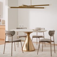 a dining room table with four chairs and a bowl on it in front of a white wall