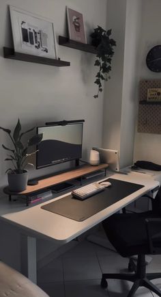 a desk with a monitor, keyboard and phone on it